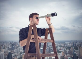 Young businessman looking for opportunities through the spyglass standing on the stairs.  Cloudy sky and city around.